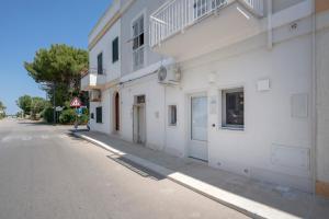 a white building on the side of a street at Dimora Sofia, Charming House in Savelletri di Fasano