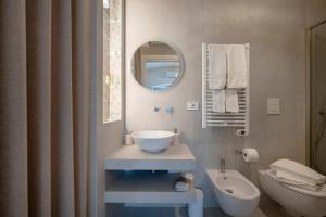 a bathroom with a sink and a toilet and a mirror at Dimora Sofia, Charming House in Savelletri di Fasano