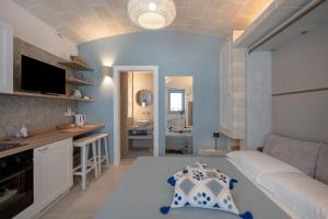 a small living room with a couch and a kitchen at Dimora Sofia, Charming House in Savelletri di Fasano