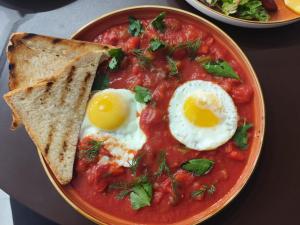 a bowl of tomato soup with eggs and toast at Avenue Hotel in Almaty