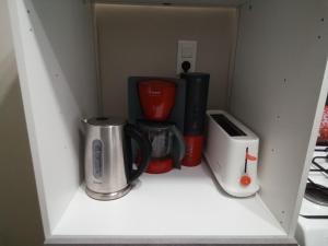 a cupboard with a coffee maker and other kitchen appliances at Les Coquillages in Essoyes