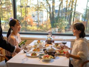 a group of people sitting around a table eating food at Izukogen Hotel Itsutsuboshi in Ito