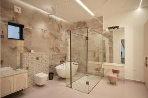 a bathroom with a glass shower and a tub at Sukoon Luxury Stay in Amritsar +68 photos