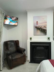 a living room with a chair and a fireplace at Wag-n-Bietjie in Centurion