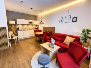 a living room with a red couch and a table at Aparthotel Bergtraum in Mühlbach am Hochkönig