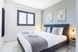 a bedroom with a large bed with two towels on it at Mayan 2-Bedroom Apartment in Larnaca
