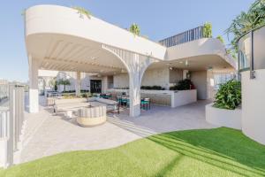an outdoor patio with a white pergola at Esprit Holidays Rainbow Bay in Gold Coast