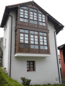 una casa con ventanas grandes en un lateral en Casa Rural Maribel II en Cue