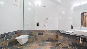 a bathroom with a shower and a toilet and a sink at Table Land Retreat in Panchgani +34 photos