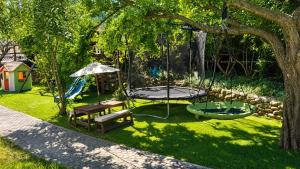 a park with a swing and a bench and a playground at Il Piccolo Aranceto in Motta SantʼAnastasia