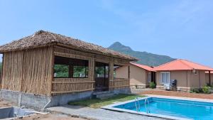 a house with a swimming pool and a hut at Anaasa Resorts in Tiruvannāmalai