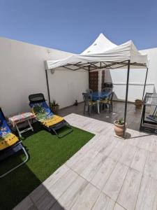 a patio with two chairs and a white umbrella at MahdiaRafeha in Mahdia