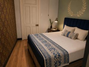 a bedroom with a bed with a blue headboard at Downtown Guest house in Santiago
