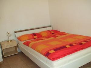 um quarto com uma cama com um edredão laranja e amarelo em Apartment OG 2 em Peine