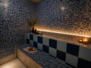 a bathroom with blue and white tiled walls and a tub at Downtown Guest house in Santiago