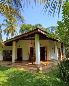 a house with a patio and a yard at The Secret Guesthouse in Mirissa