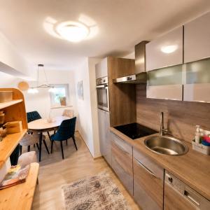 a kitchen with a sink and a dining table at Apartment Ledermoos - Ski, Langlauf & Wandern in Mauterndorf in Mauterndorf
