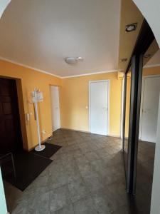 an empty room with yellow walls and tile floors at Mugavustega avar perekorter 3toaline in Võru
