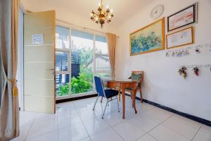 a dining room with a table and chairs and a window at RedDoorz at Batutulis Bogor Villa Papatong by M in Bogor