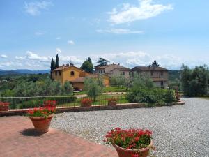 een huis met twee potten bloemen op een oprit bij Agriturismo Il Pintello in San Casciano in Val di Pesa
