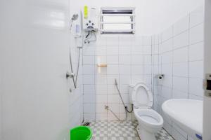 a bathroom with a shower and a toilet and a sink at RedDoorz at Batutulis Bogor Villa Papatong by M in Bogor +23 photos