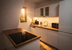 a small kitchen with a sink and a microwave at Ferienwohnung Niki am Straussee Seeblick und Kamin für bis zu 12 Personen in Strausberg +8 photos