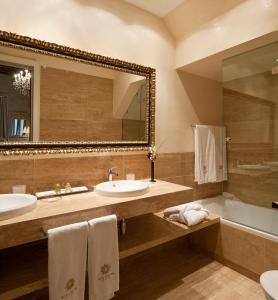 a bathroom with two sinks and a large mirror at Hotel Casa 1800 Sevilla in Seville