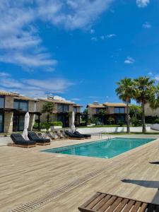a swimming pool with chaise lounge chairs next to a resort at Villa Palma in Kallithea Halkidikis