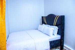 a bed with white sheets and pillows in a room at JULIAH NASERIAN BnBS in Narok