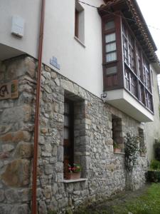 un edificio con una pared de piedra y ventanas en Casa Rural Maribel II, en Cue