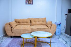 a living room with a couch and two tables at JULIAH NASERIAN BnBS in Narok