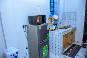 a microwave on top of a refrigerator in a room at JULIAH NASERIAN BnBS in Narok +6 photos
