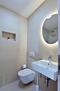 a bathroom with a sink and a toilet and a mirror at House Santro in Baška Voda +70 photos