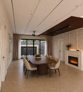 a dining room with a table and chairs and a fireplace at Sukoon Luxury Stay in Amritsar