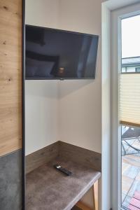 a flat screen tv on a wall in a room at Apartment Alpenstyle Ennstal in Aich +59 photos