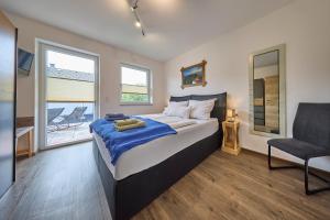 a bedroom with a bed and a chair in it at Apartment Alpenstyle Ennstal in Aich