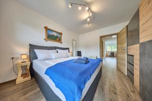 a bedroom with a large bed with a blue blanket at Apartment Alpenstyle Ennstal in Aich