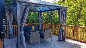 ein Pavillon mit Tisch und Stühlen auf einer Terrasse in der Unterkunft Grey House in Laufen