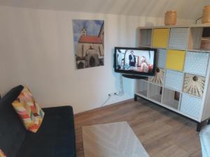 ein Wohnzimmer mit einem Fernseher an der Wand in der Unterkunft Grey House in Laufen