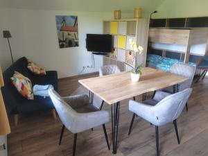 ein Wohnzimmer mit einem Holztisch und Stühlen in der Unterkunft Grey House in Laufen + 7 Fotos