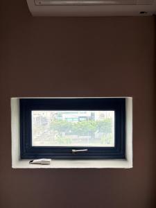 a window in a wall with a black and white at Hostel K wave Only Female Hongdae in Seoul