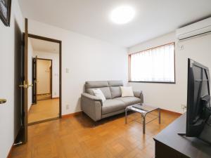 a living room with a couch and a television at 雪の宿 in Numata