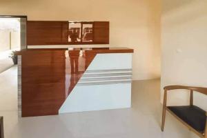 a room with a bench and a table and a chair at Jatiwangi Syariah Guest House Mitra RedDoorz in Majalengka +6 photos
