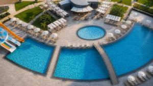 an overhead view of two pools with chairs and umbrellas at Rıversıdelıfe Iskele M 147 in Aglantzia +9 photos