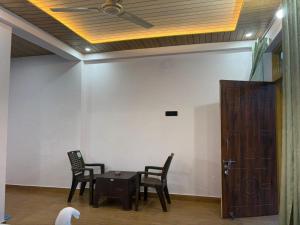 a white dog standing in a room with a table and chairs at Pahadi Aangan Chakrata in Kailāna