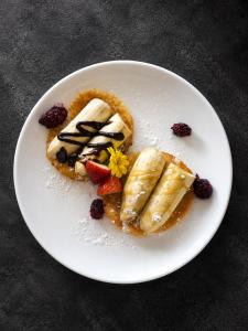 a white plate with a dessert with fruit on it at Luna Hut Resort in Hua Hin