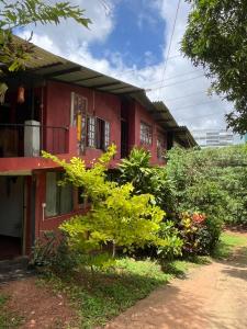 a red house with a tree in front of it at Coca Cola Hostel Malabe in Malabe