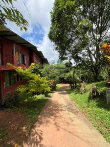 a dirt road next to a red building at Coca Cola Hostel Malabe in Malabe +51 photos