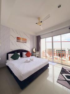 a bedroom with a large bed and a balcony at Kata Beachwalk Hotel and Bungalows in Kata Beach +48 photos