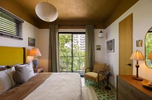 a bedroom with a bed and a chair and a window at CASA FRIDA by DW in San Juan